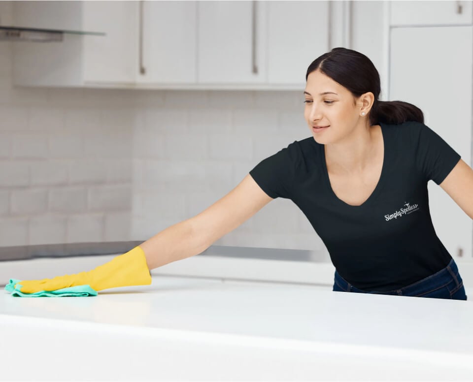 Simply Spotless cleaner, cleaning a modern bathroom inside a customer home