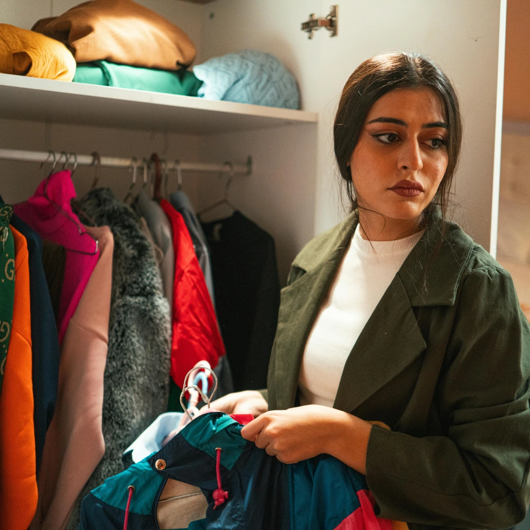 A woman standing in front of an open wardrobe 